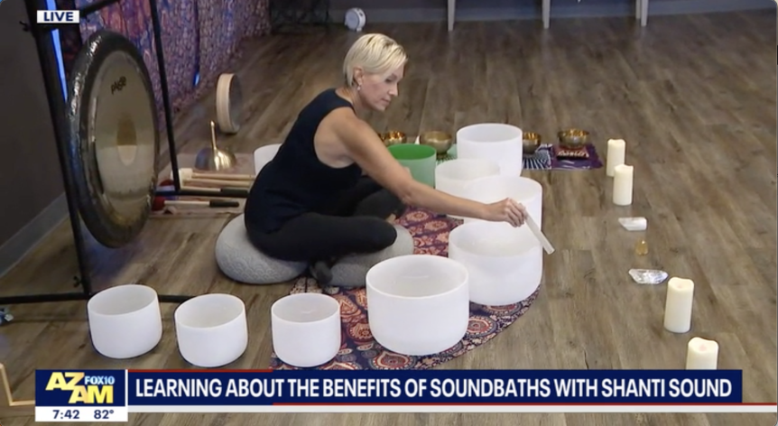 Learning About the Healing Benefits of Sound Baths with Shanti Sound written in text with Cary playing sound bowls in background